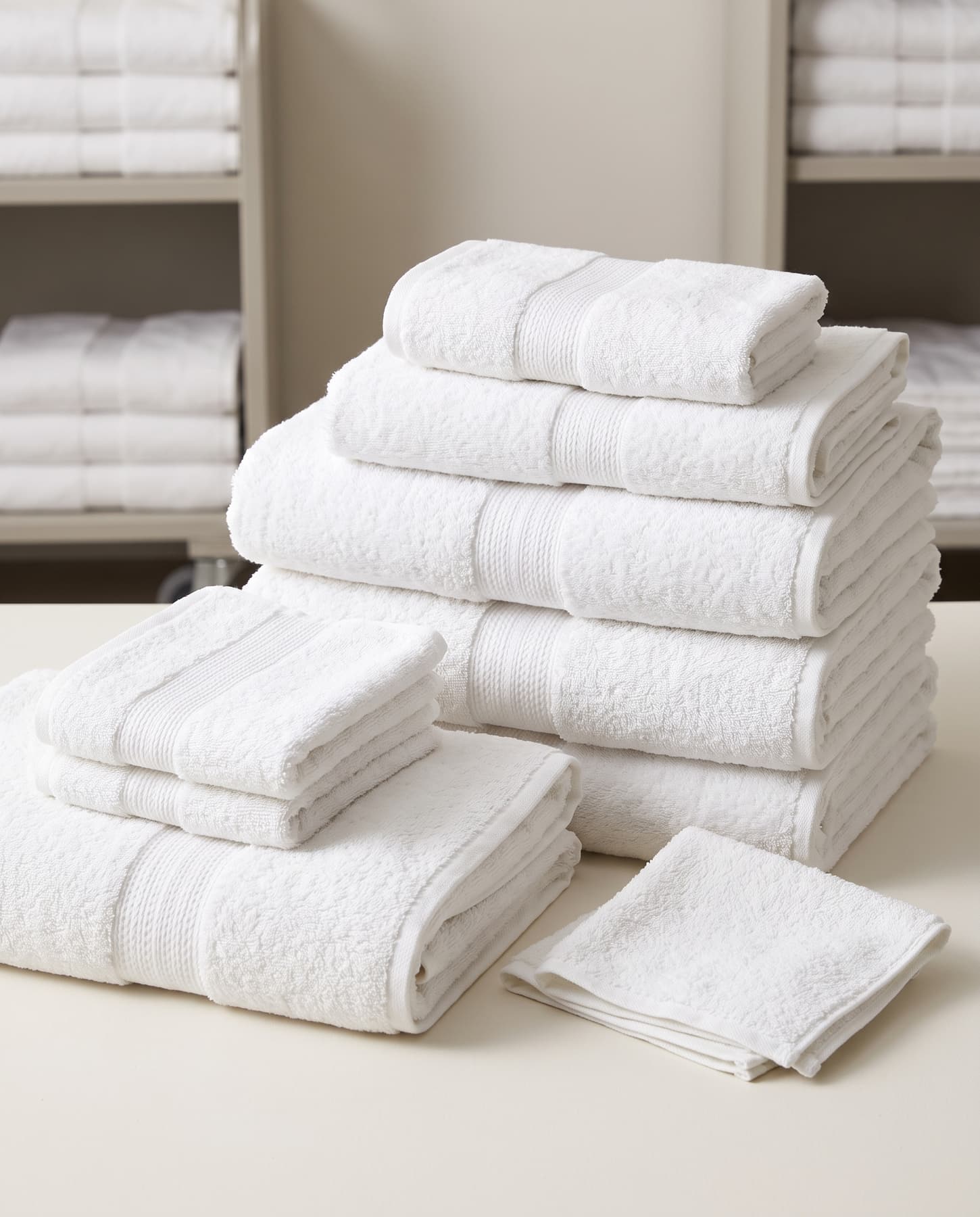 A stack of white hotel bath, hand and face towels with dobby borders