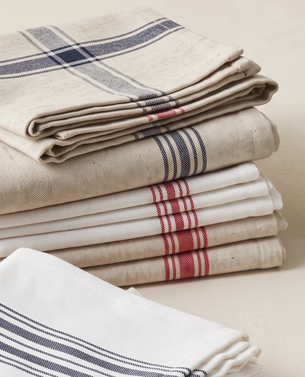 Folded flat-weave tea towels with navy and red stripes